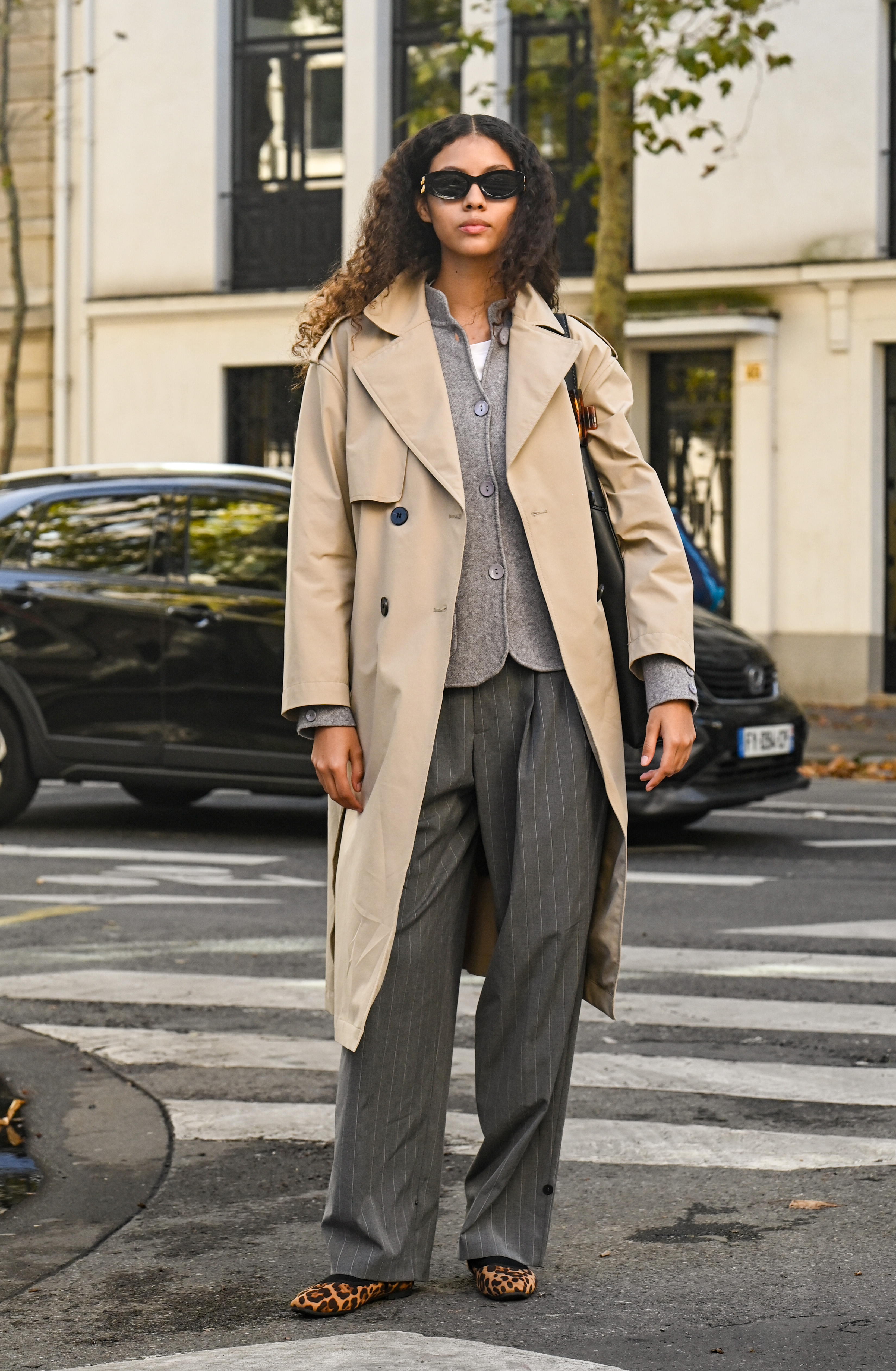 woman wearing trench coat, sweater, trousers, and flats