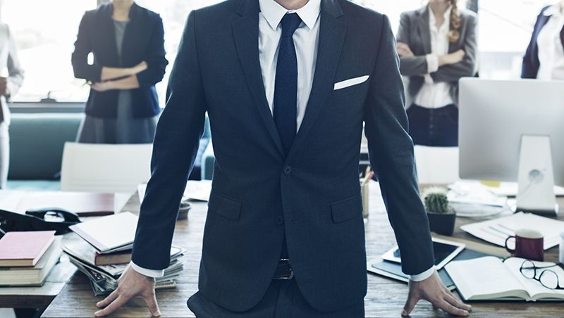 Man in a suit with office colleagues in boardroom