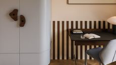 a light blue cabinet with wood handles and a wood striped wall
