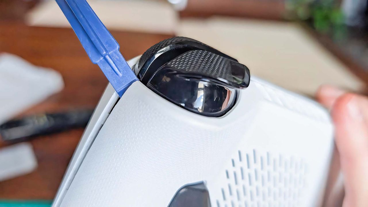 The included prying tool opening the ROG Ally casing from the right bumper area.
