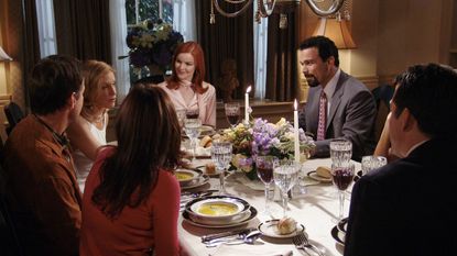 Desperate housewives cast around dining table with candles, flowers and glassware
