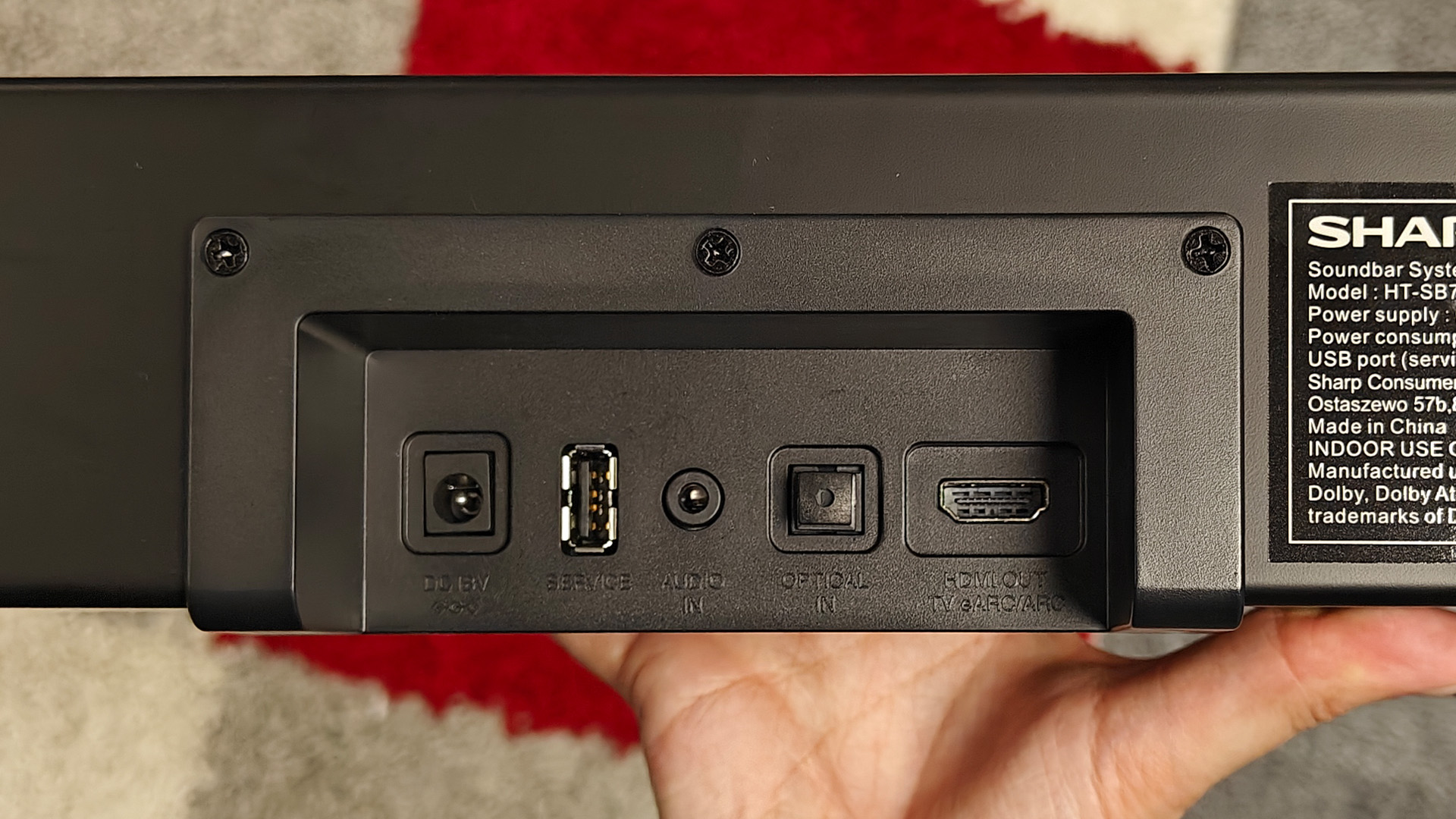 Sharp HT-SB700 Dolby Atmos soundbar held in hand showing rear connections