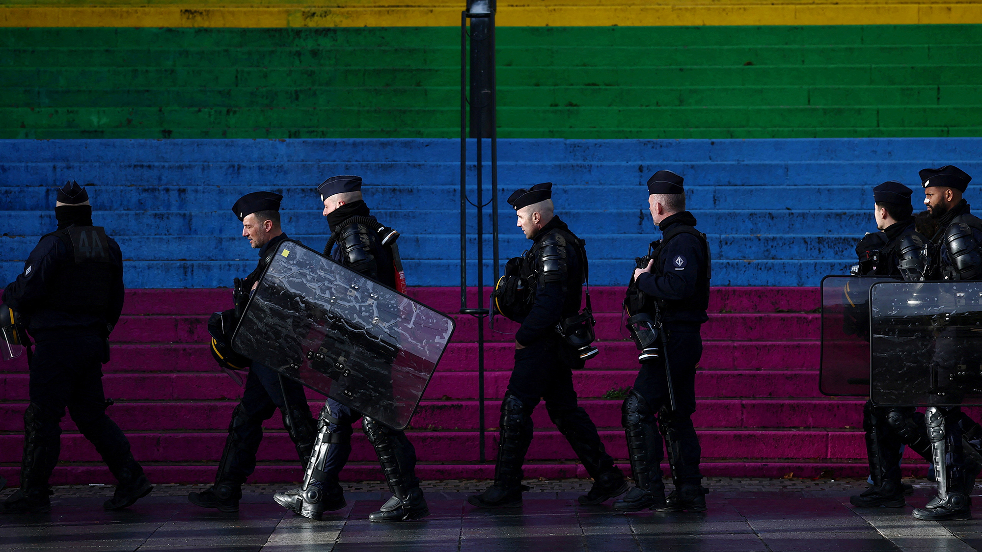 CRS police walk past rainbow-colored stairs during a demonstration against austerity measures in Nantes, France