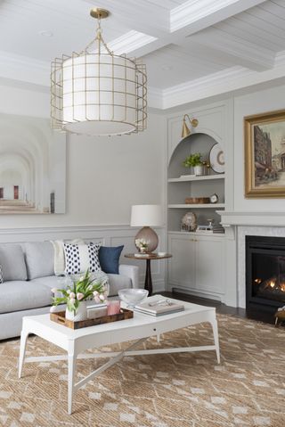 An example of how to design a living room with a neutral color scheme, white coffee table and statement pendant light.