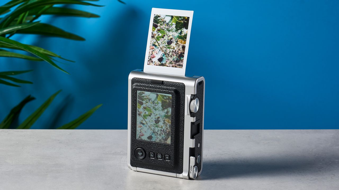 A black and gray Fujifilm Instax mini Evo hybrid instant camera