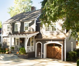wooden garage doors with gray clapboard house