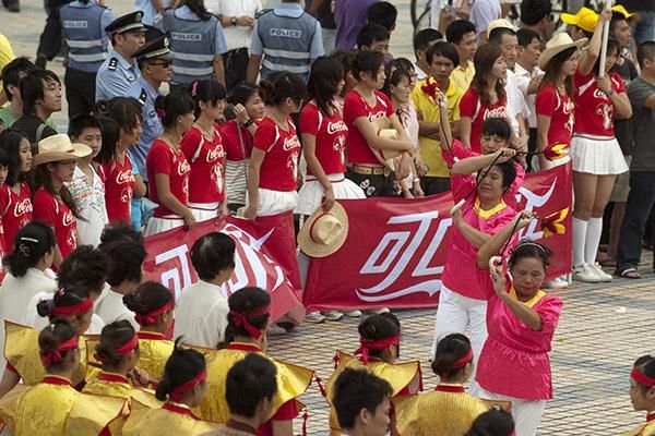 Performers wait their turn as they watch others in action at the post-stage presentations in Haikou.