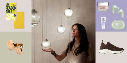 In a collaged image, a series of travel essentials, including a book, a notebook, a ring, skincare products, shoes, and earbuds, sit in square portions, while at the center a woman dressed in a beige top checks a multi-sphere light installation.