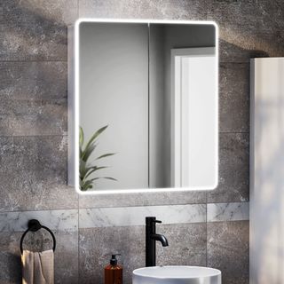 bathroom mirror with LED light around edge on grey tiled wall above white round sink with black tap