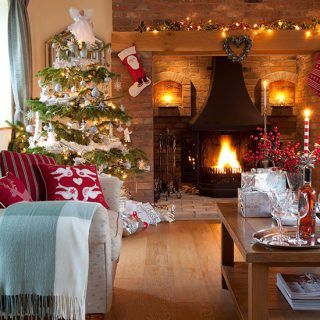 living room with christmas decorations sofa with cushion fire place and wooden flooring