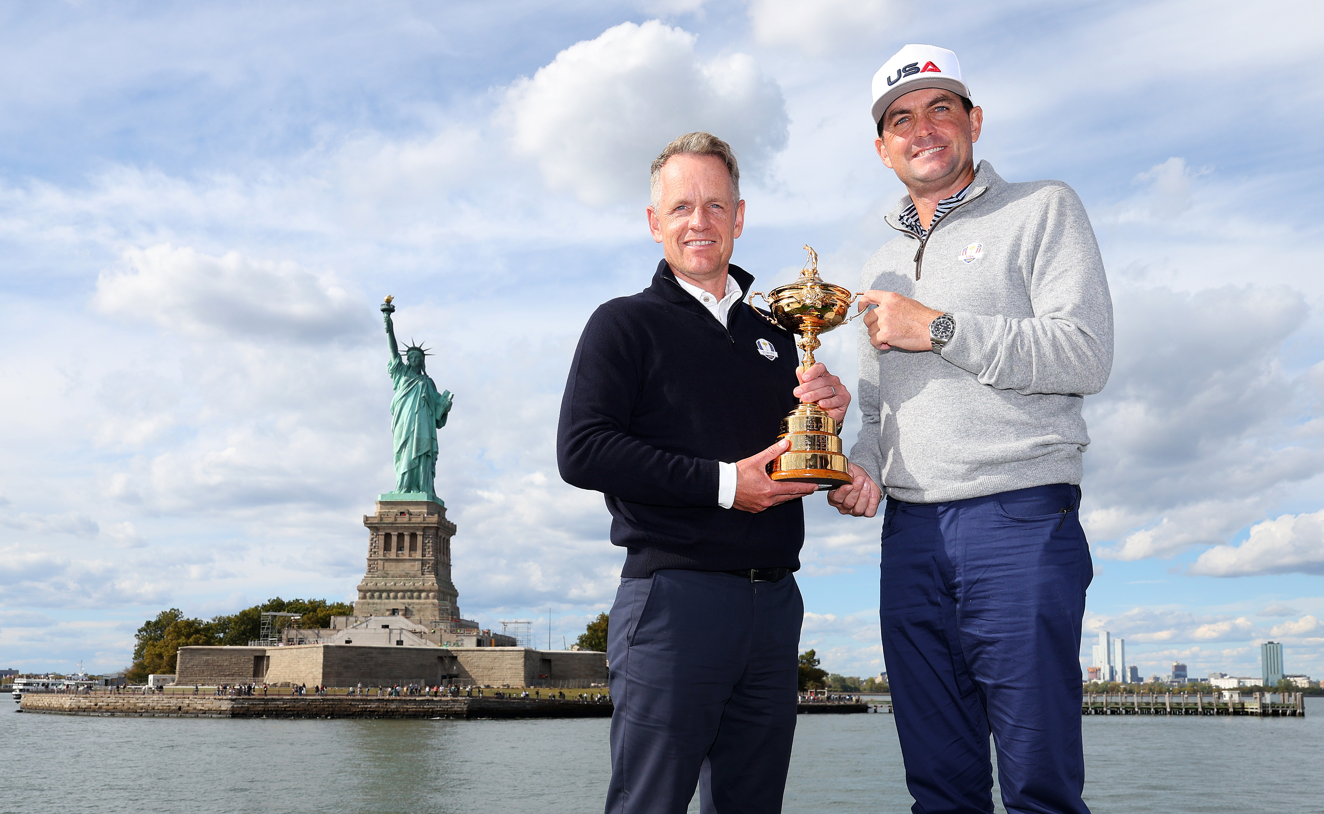 Luke Donald and Keegan Bradley hold the Ryder Cup in front of the Statue of Liberty