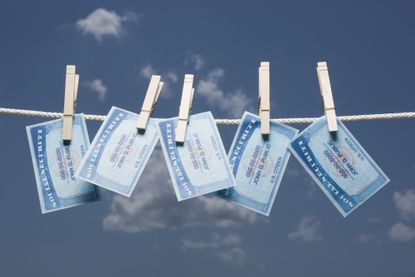 five Social Security cards pinnned on a clothesline against a blue sky