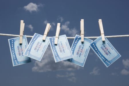 five Social Security cards pinnned on a clothesline against a blue sky