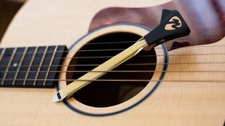 the pickaso guitar bow attached to an acoustic guitar
