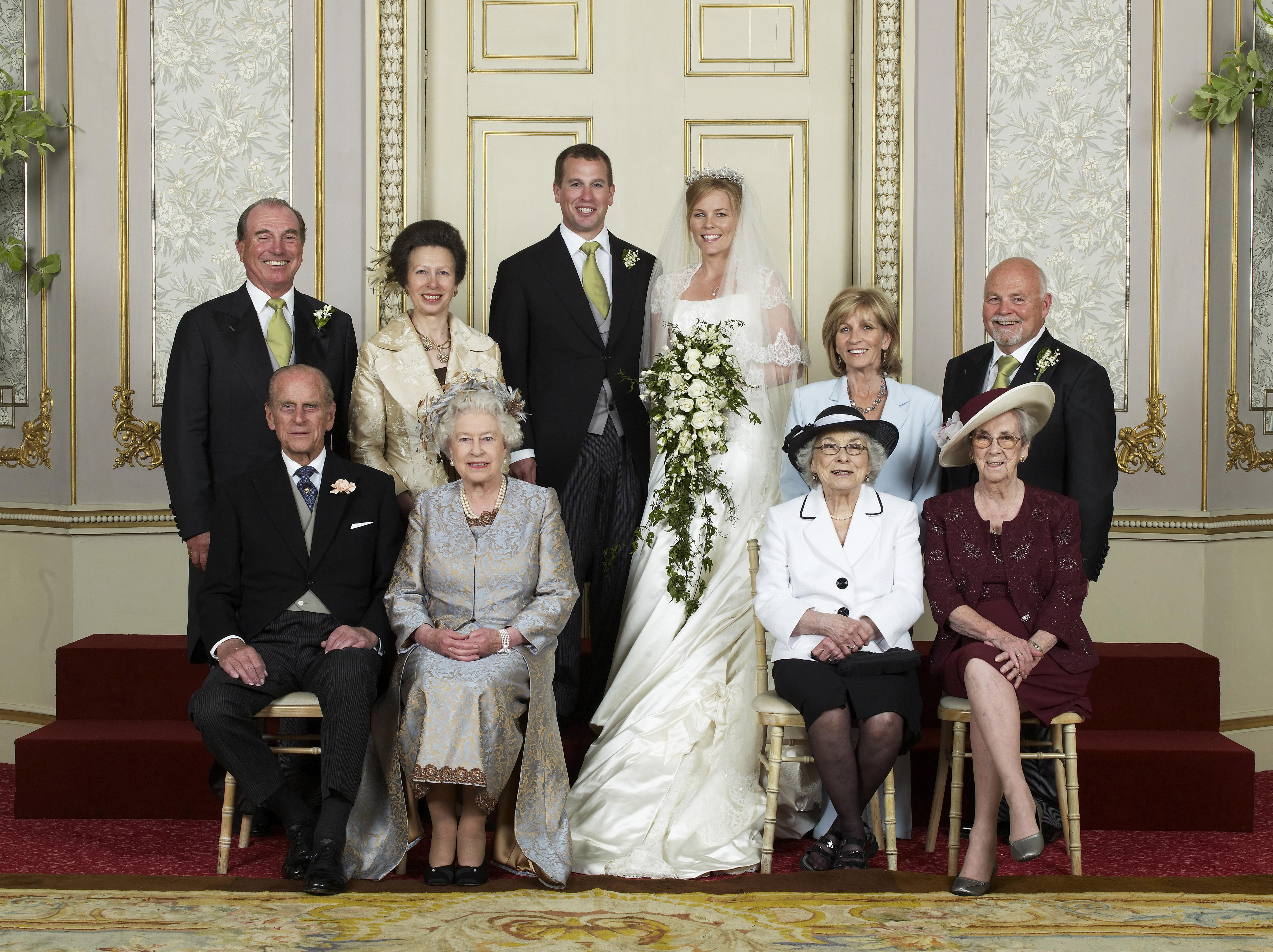 Queen Elizabeth and Prince Philip posing with Autumn Kelly and Peter Phillips, Princess Anne, Mark Phillips and in-laws on their wedding day