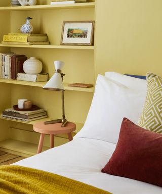 Integrated bedroom shelves painted yellow same as wall colour