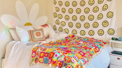 Colorful bedroom with daisy mural and smiley face tapestry