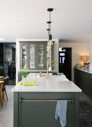 Green kitchen with island and bulb pendant lights