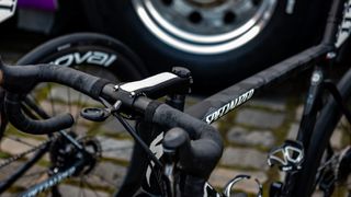 Specialized Roubaix bike on some cobblestones in front of a team car