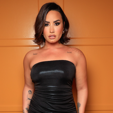 Demi Lovato wear a black tube dress and a flipped bob hairstyle.