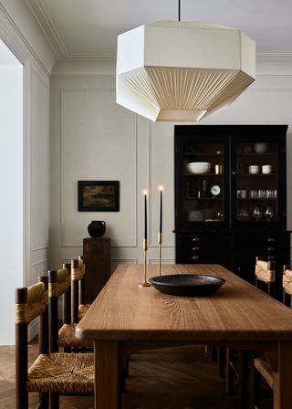 A neutral modern dining room with vintage accents and a large wooden dining table