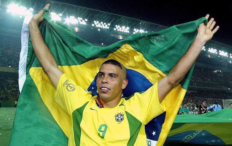 Ronaldo holds up a Brazil flag to celebrate winning the 2002 World Cup