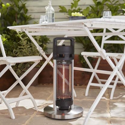Swan patio heater sitting underneath a white garden table and chairs