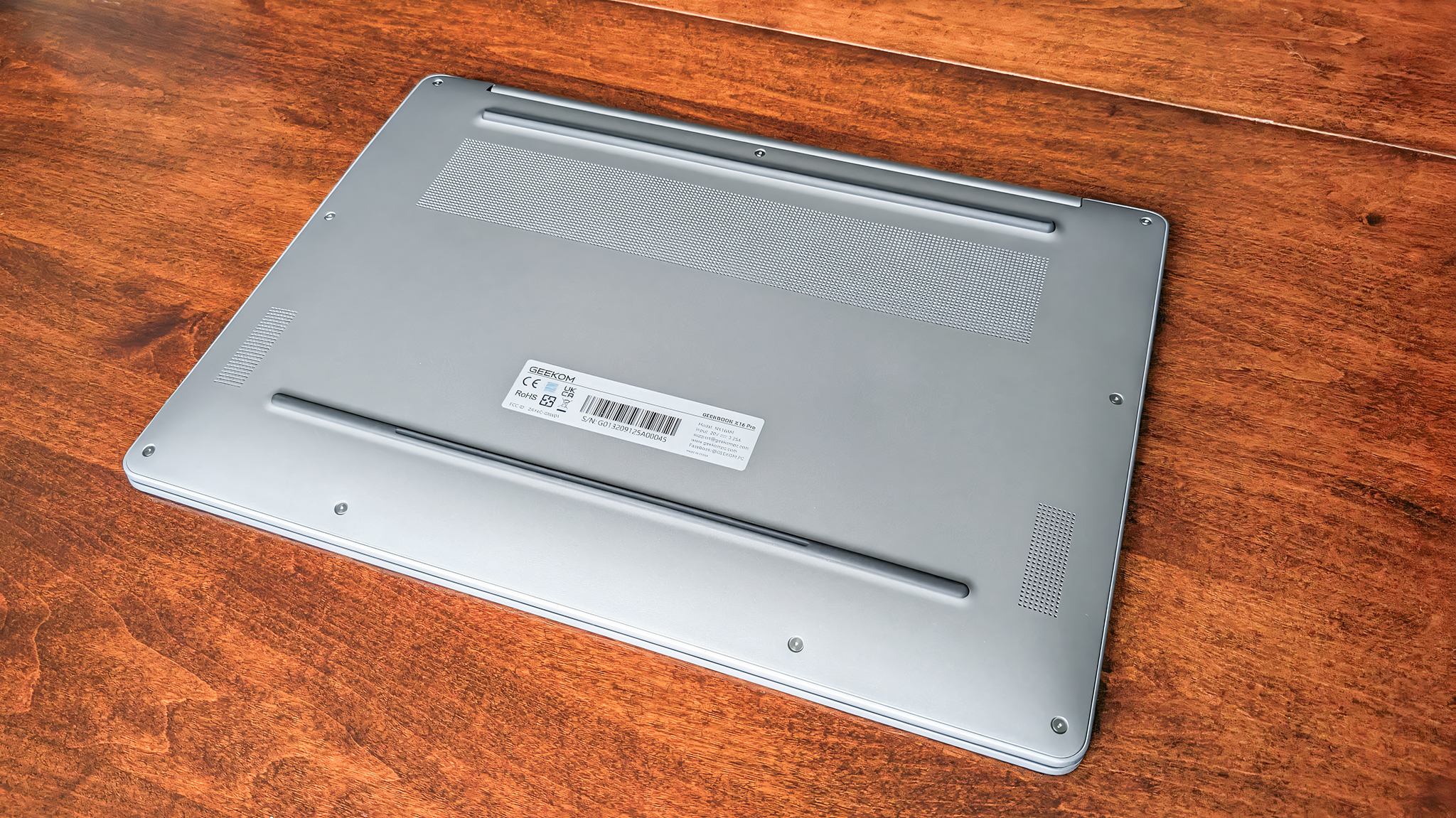 The underside of a Geekom GeekBook X16 Pro sitting on a table. 