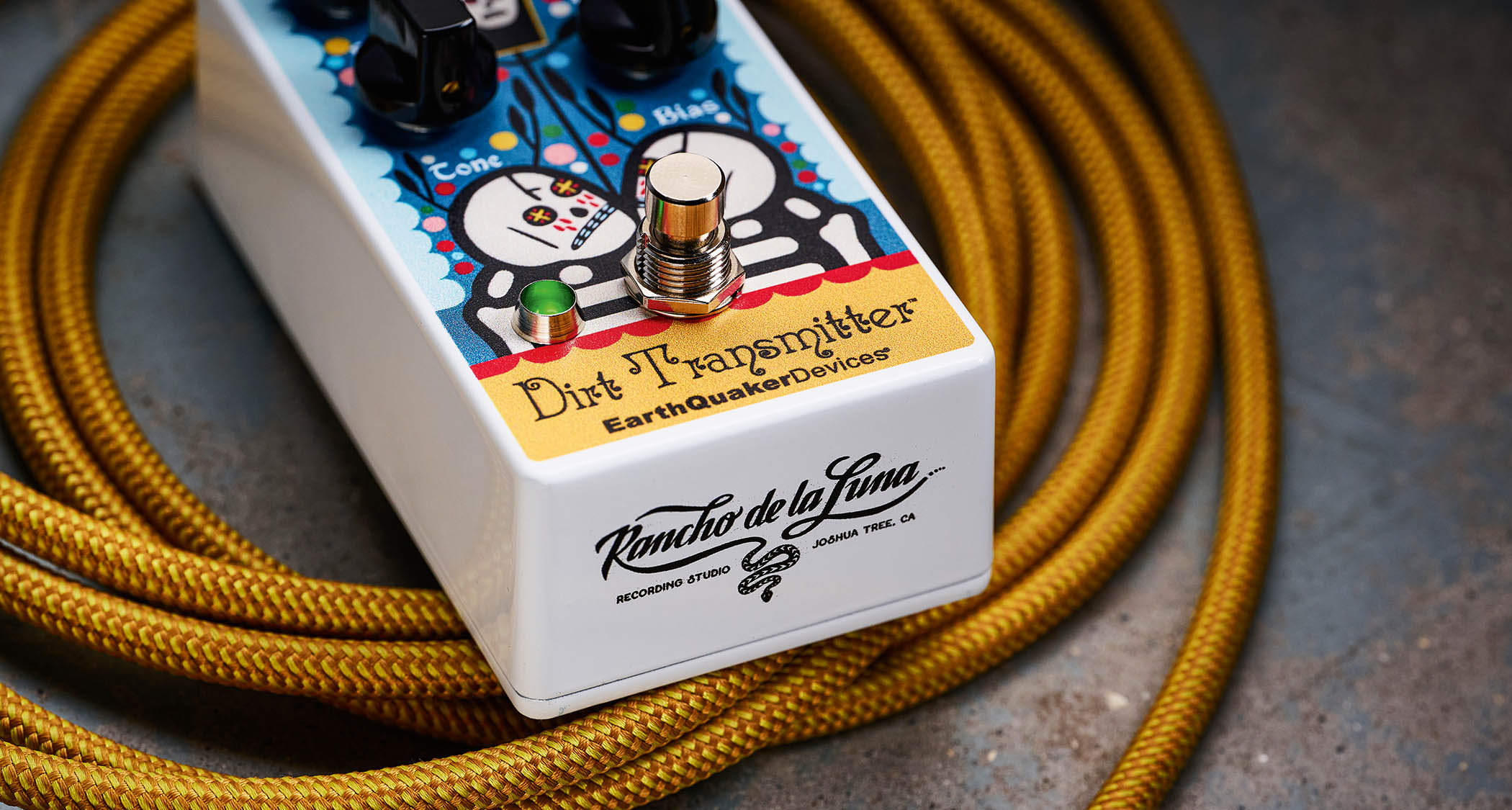 EarthQuaker Devices Rancho de la Luna Dirt Transmitter Fuzz Driver photographed on top of a tweed yellow guitar cable.