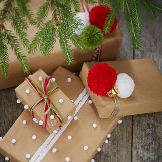 Presents wrapped in brown wrapping paper with tiny pom poms