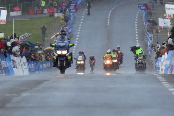 Surrounded by motorcycles, Marianne Vos (Rabo Women) appraoches the finish line and victory