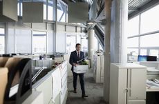  photo of man leaving office with box of materials.