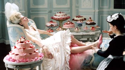 A still from the film adaptation of Marie Antoinette played by Kirsten Dunst, reclining on a chair