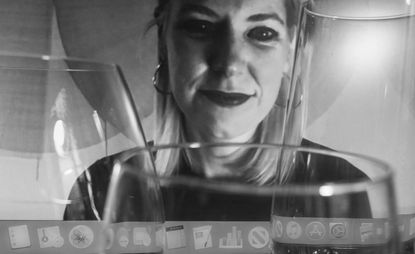 Black and white image of Sabine Marcelis with wine glasses in the foreground
