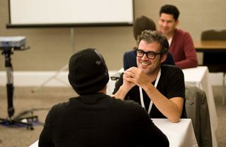 An attendee at Generate 2013 chats with Oliver Reichenstein