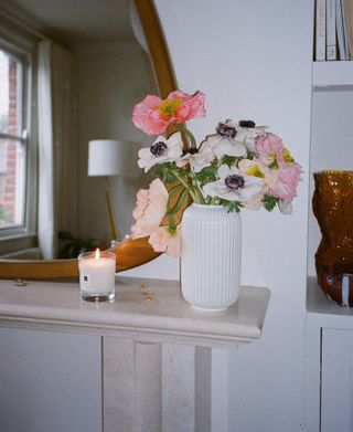 a picture of a Jo Malone candle next to a vase of flowers