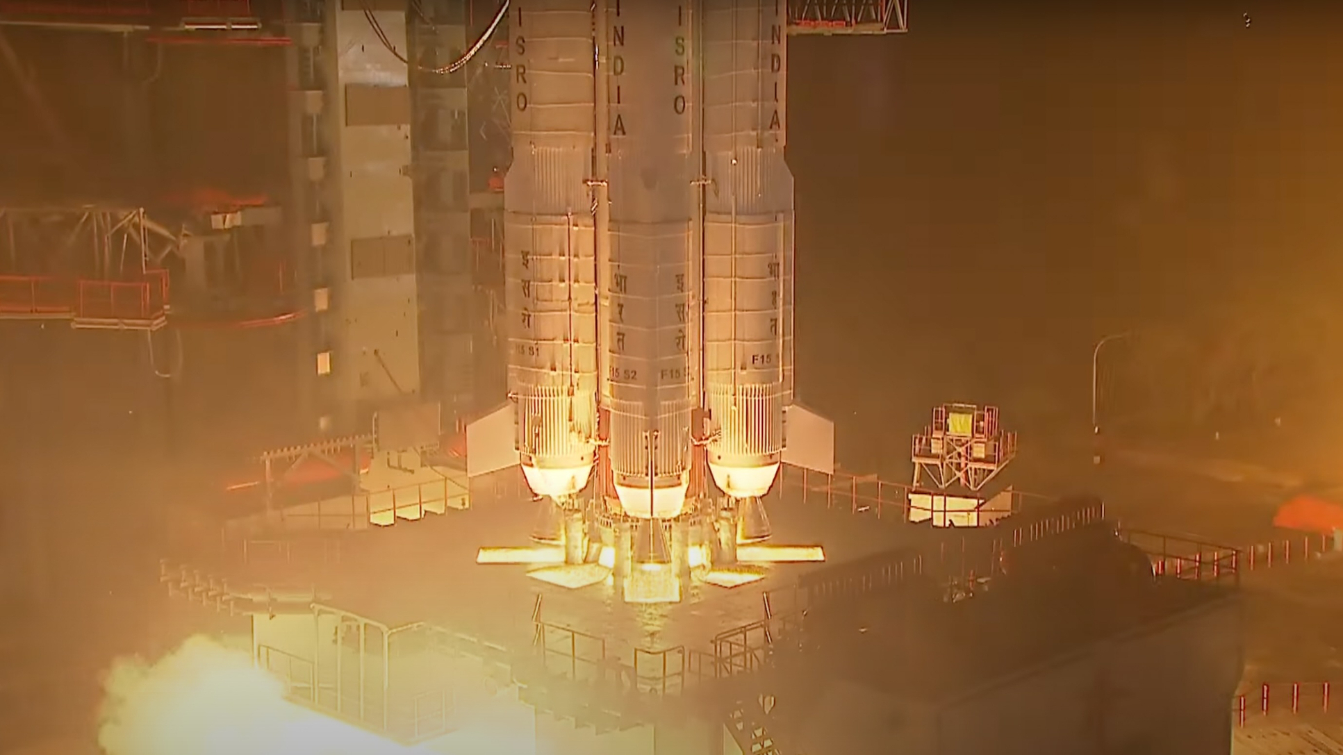 closeup of a rocket's base, showing its engines igniting on the ground during a nighttime launch