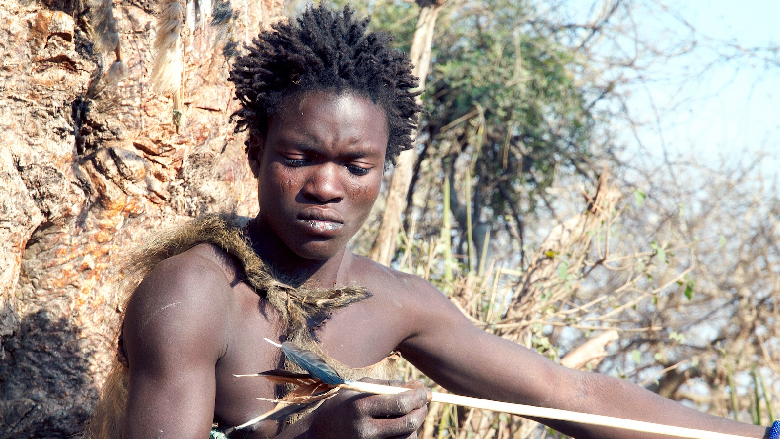 Hadza man making an arrow