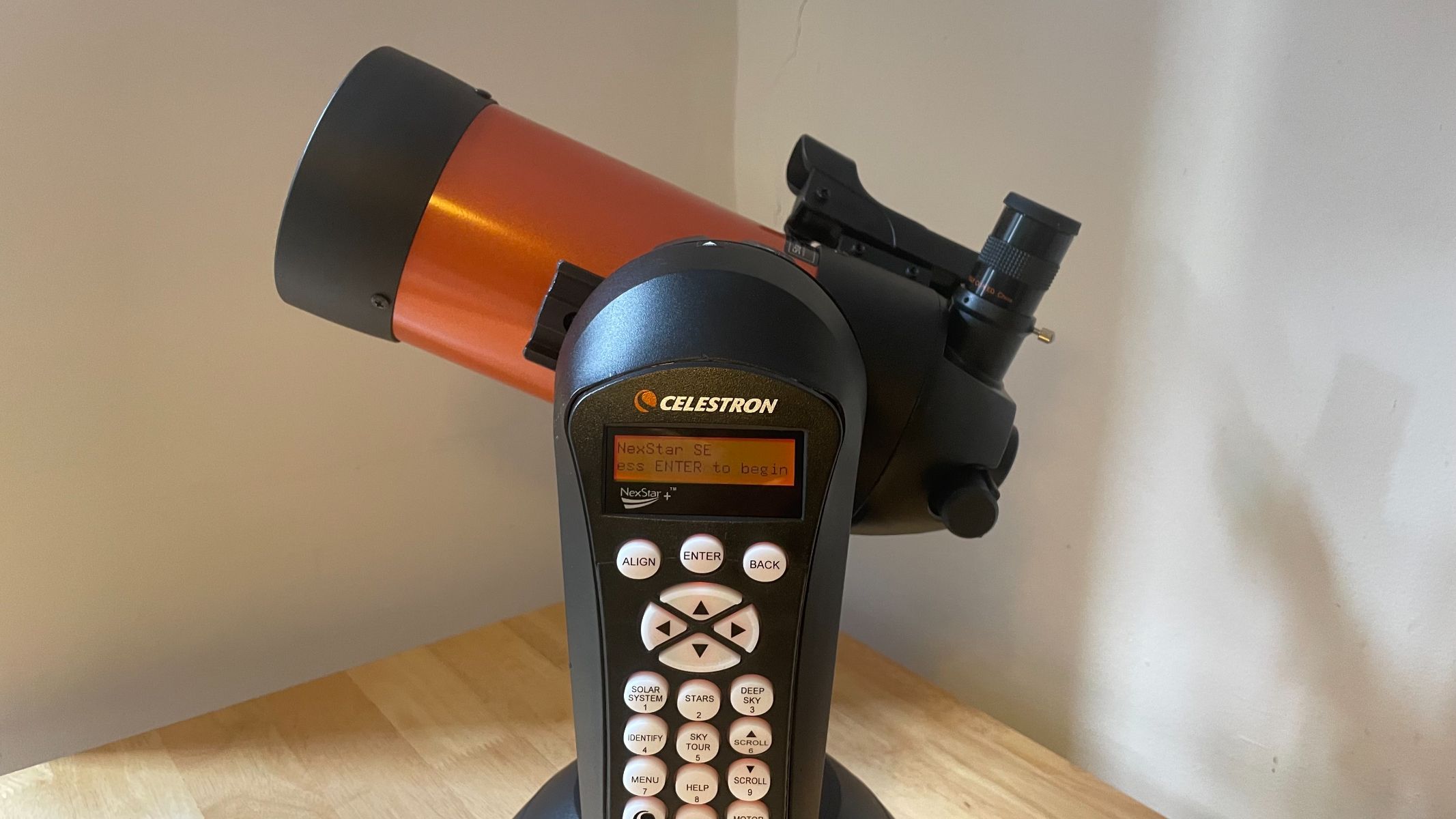 A side view of the telescope on a wooden table