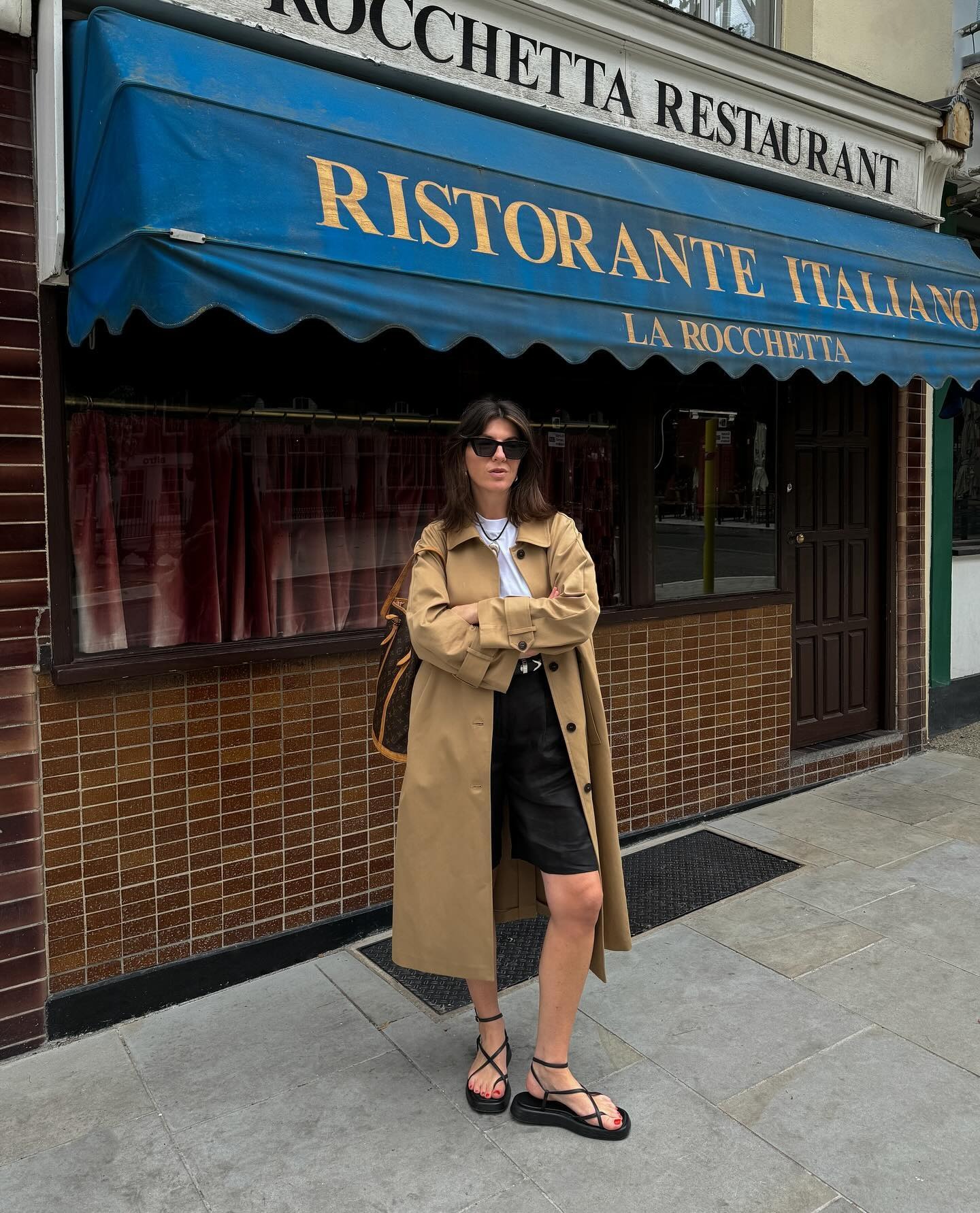 Mujer viste gabardina, pantalones cortos de lino y sandalias.