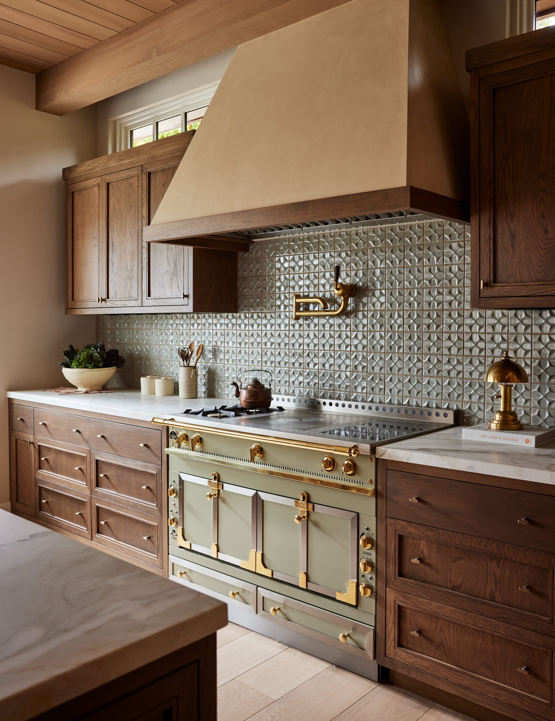 A wooden kitchen with a green tiled backsplash and green range cooker