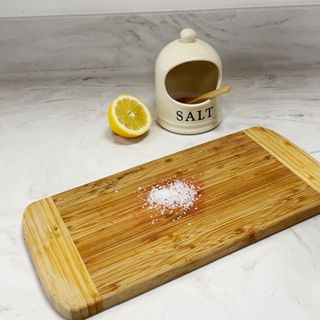 Cleaning wooden chopping board with salt and lemon