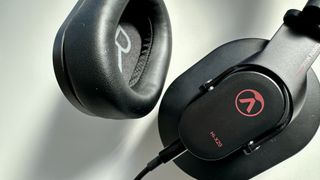 Austrian Audio Hi-X20 over-ear headphone cups, with wired connection on a white surface