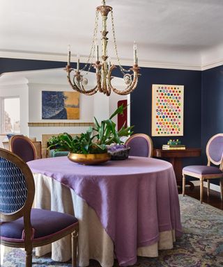 dining room with navy blue wall, lilac table cloth and purple chairs