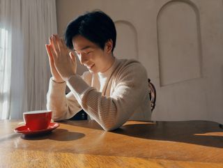 A OnePlus 10 Pro sample image of a person sitting at a table with a coffee cup