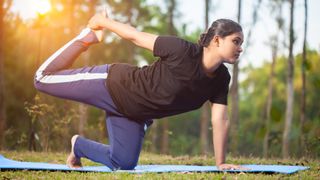 A woman holding the Tiger pose