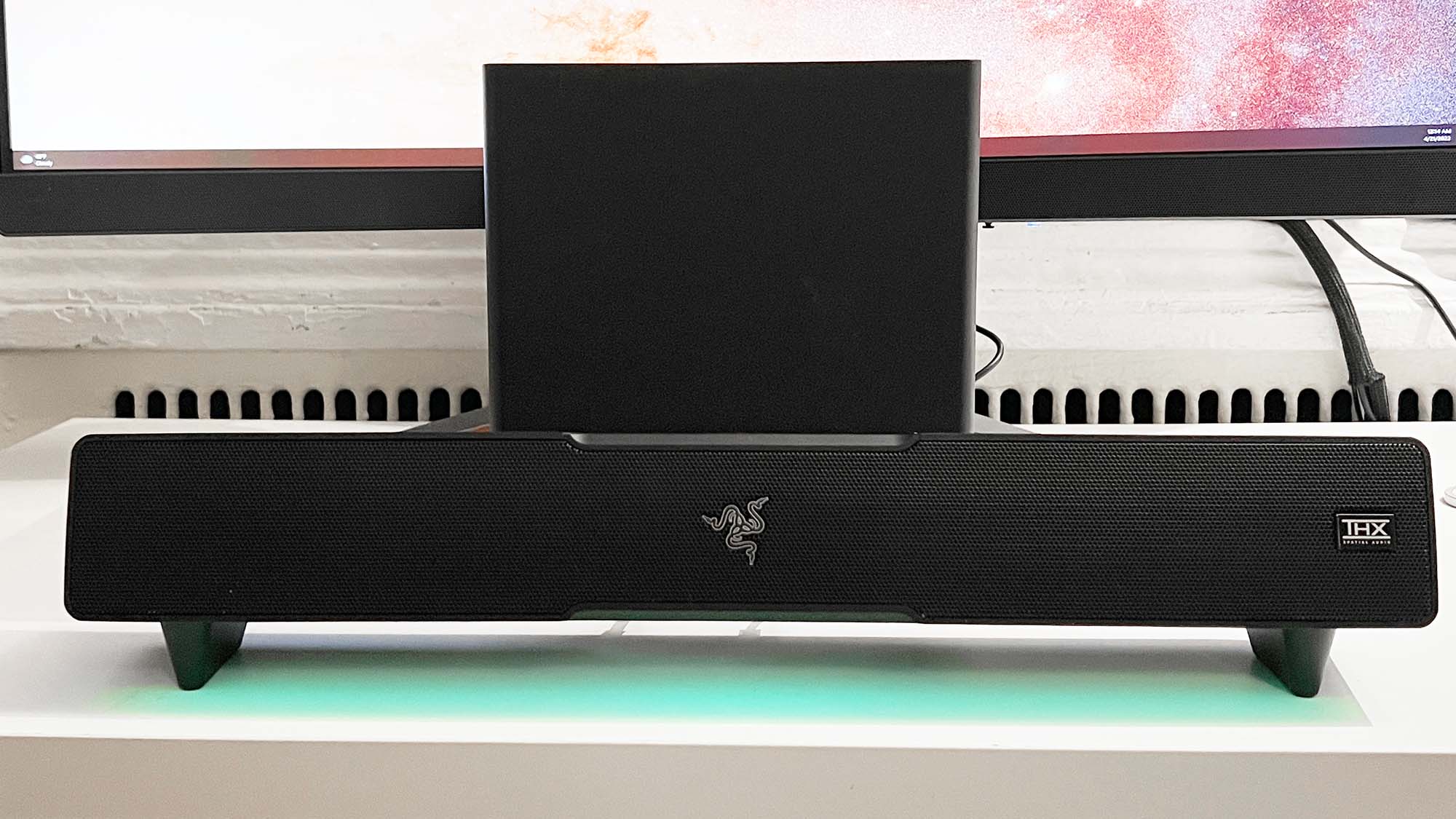 Um Razer Leviathan V2 em uma mesa em frente a um monitor