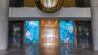 A vibrant and colorful digital display full of shades of blue highlights the entryway in a Dallas property.