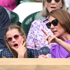 Princess Charlotte looks shocked while wearing a navy and white polka dot dress at Wimbledon, as her mom Kate Middleton points