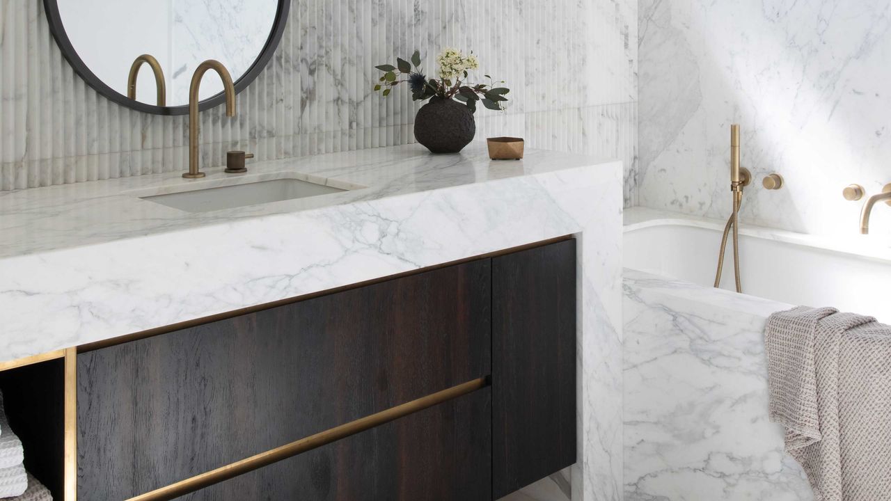 a modern white bathroom with dark wood cabinets